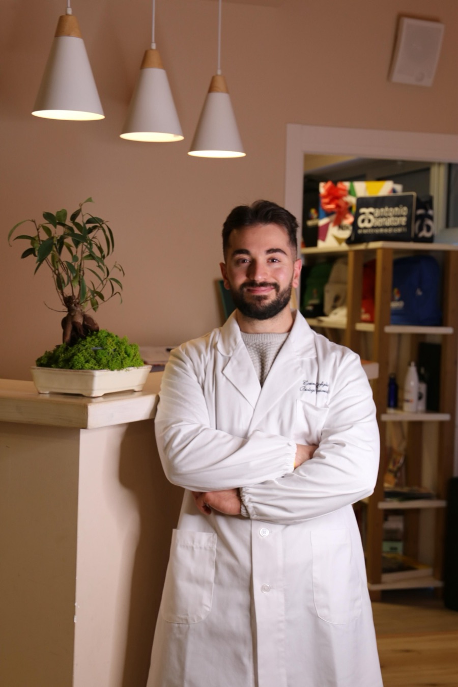 Il dott. Cosimo Buonofiglio in camice, a braccia conserte, nel suo studio